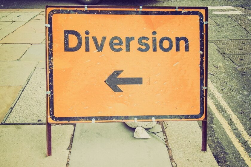 Restrukturierung / Umleitungsschild auf einem Bürgersteig – Symbol für Richtungswechsel im Unternehmen