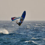 Windsurfer springt über die Wellen – Sinnbild für Mut, Energie und den Sprung in die Selbstständigkeit mit Gründungszuschuss