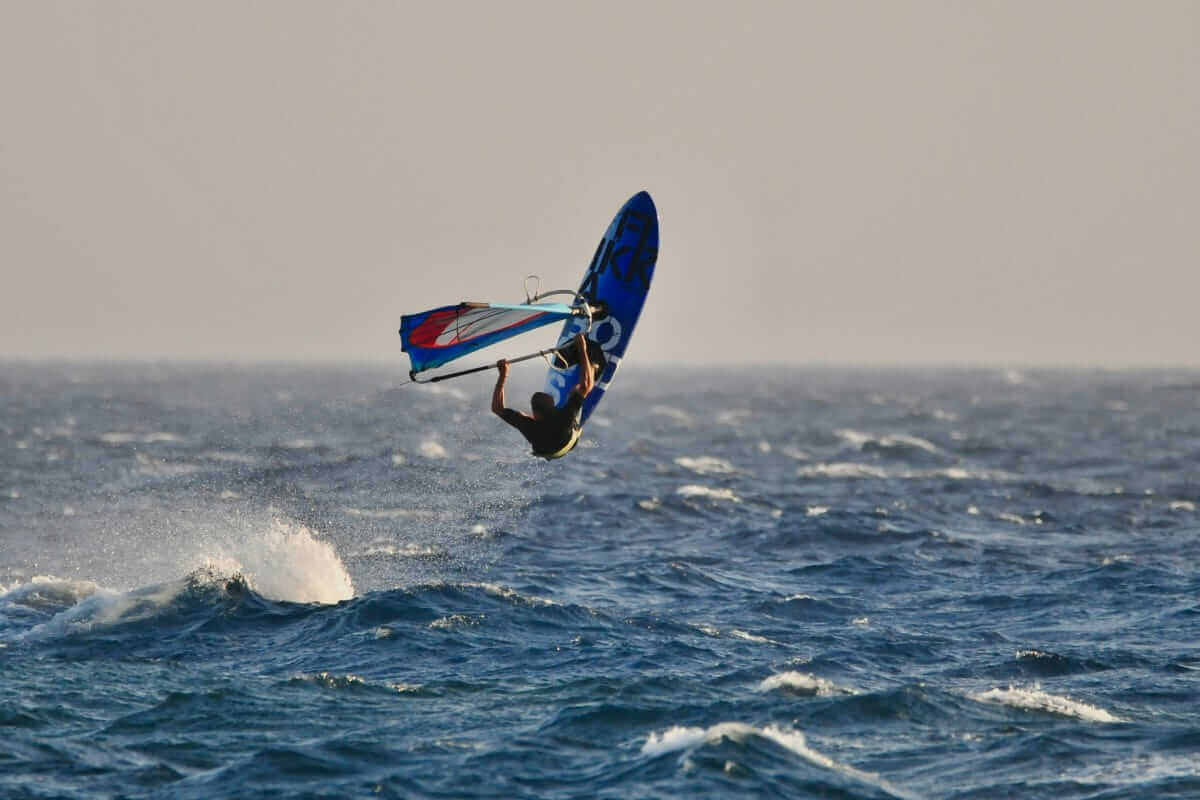 Windsurfer springt über die Wellen – Sinnbild für Mut, Energie und den Sprung in die Selbstständigkeit mit Gründungszuschuss