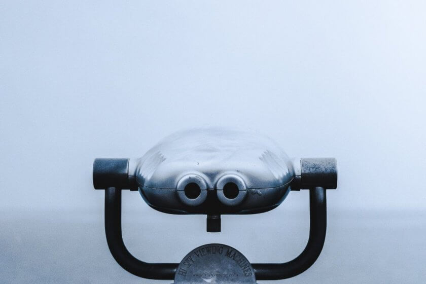 Bonitätsprüfung / Münzfernrohr vor nebligem Hintergrund – Symbolbild für Bonitätsprüfung und genaues Hinschauen bei Geschäftspartnern