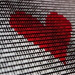 Cybersicherheit, IT-Innovationen / Binärcode auf einem Bildschirm zeigt ein rotes Herz – Symbol für den menschlichen Faktor in der Cybersecurity.