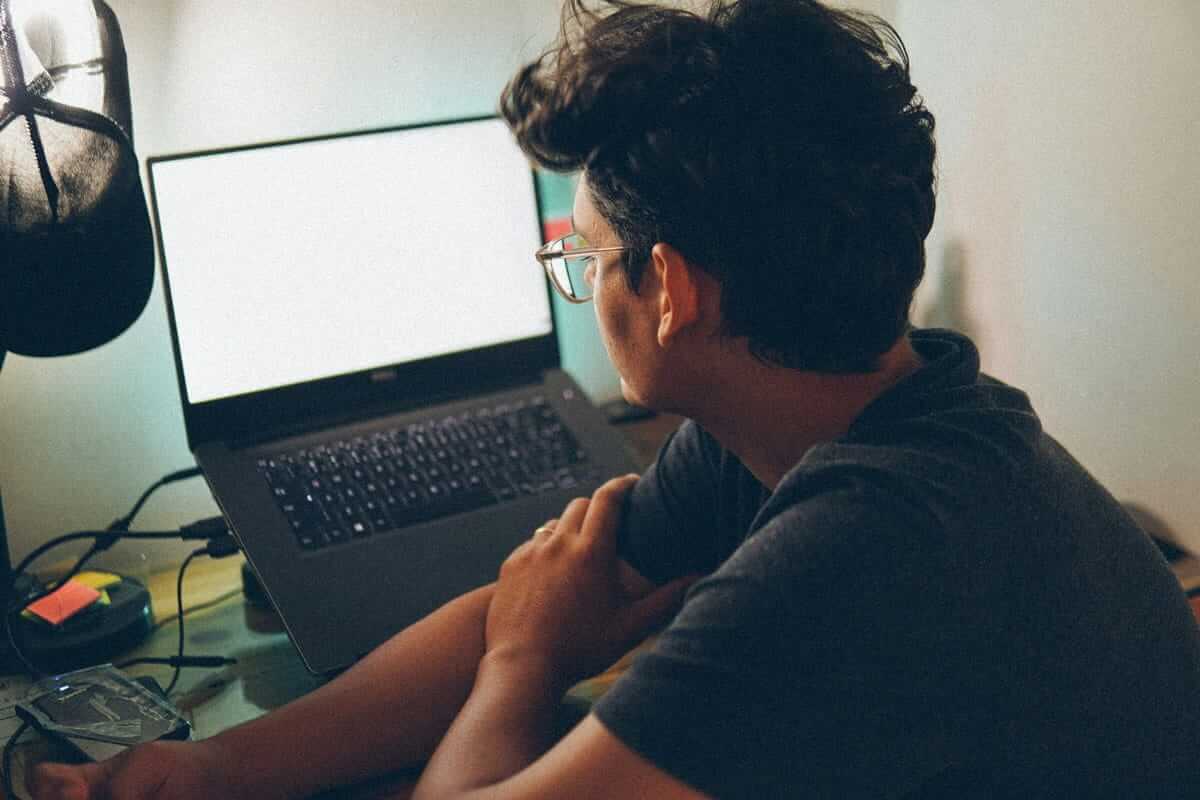 Mann von hinten am Laptop im Homeoffice