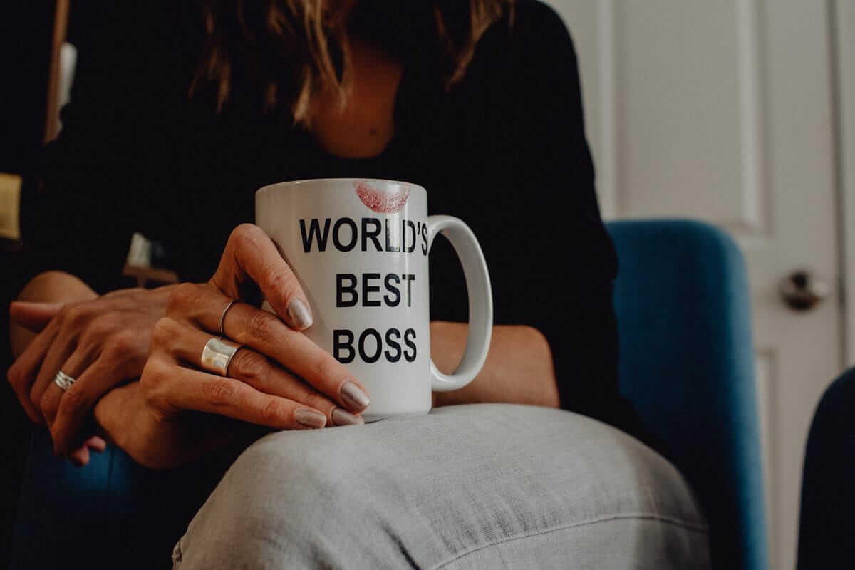 weiblich. selbstständig. ERFOLGREICH. - Woman's hand holding "World's Best Boss" mug