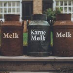 Kostenverteilungsmethode, a cute scenery in a little dutch village with three milk cans staning on a little step outside a an olf farm
