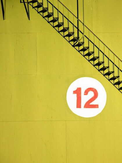 Wie du produktiver wirst – 12 Gewohnheiten erfolgreicher Menschen (Treppe mit Schild auf dem eine 12 steht)