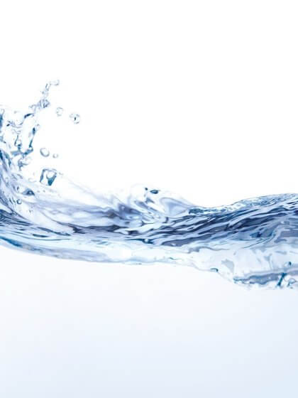 Liquidität / Nahaufnahme eines Spritzes Wasser, das eine florale Form bildet, einzeln auf weißem Hintergrund.