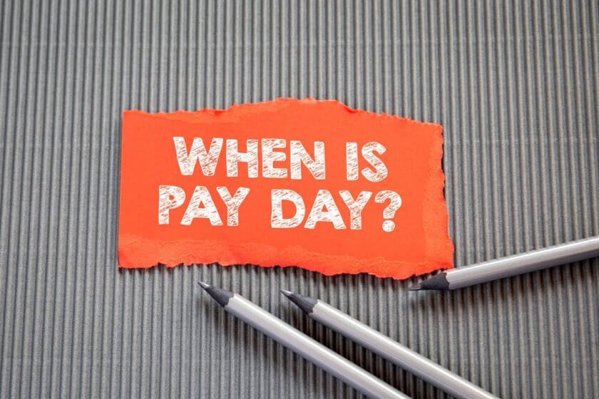Lohnabrechnung, Lohnabrechnungssoftware (PAY DAY concept. Text on torn, colored paper on corrugated background)