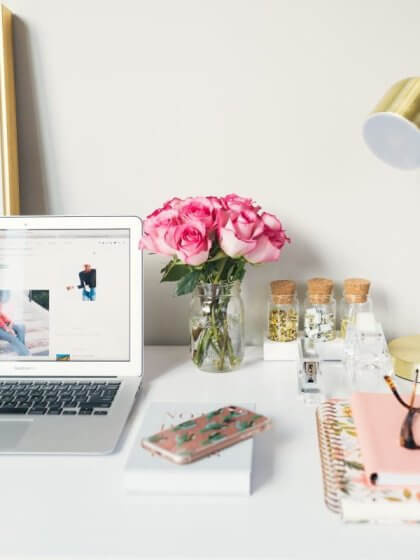 Blumen, Motivation (MacBook Air neben goldener Arbeitslampe und Spiralbüchern)