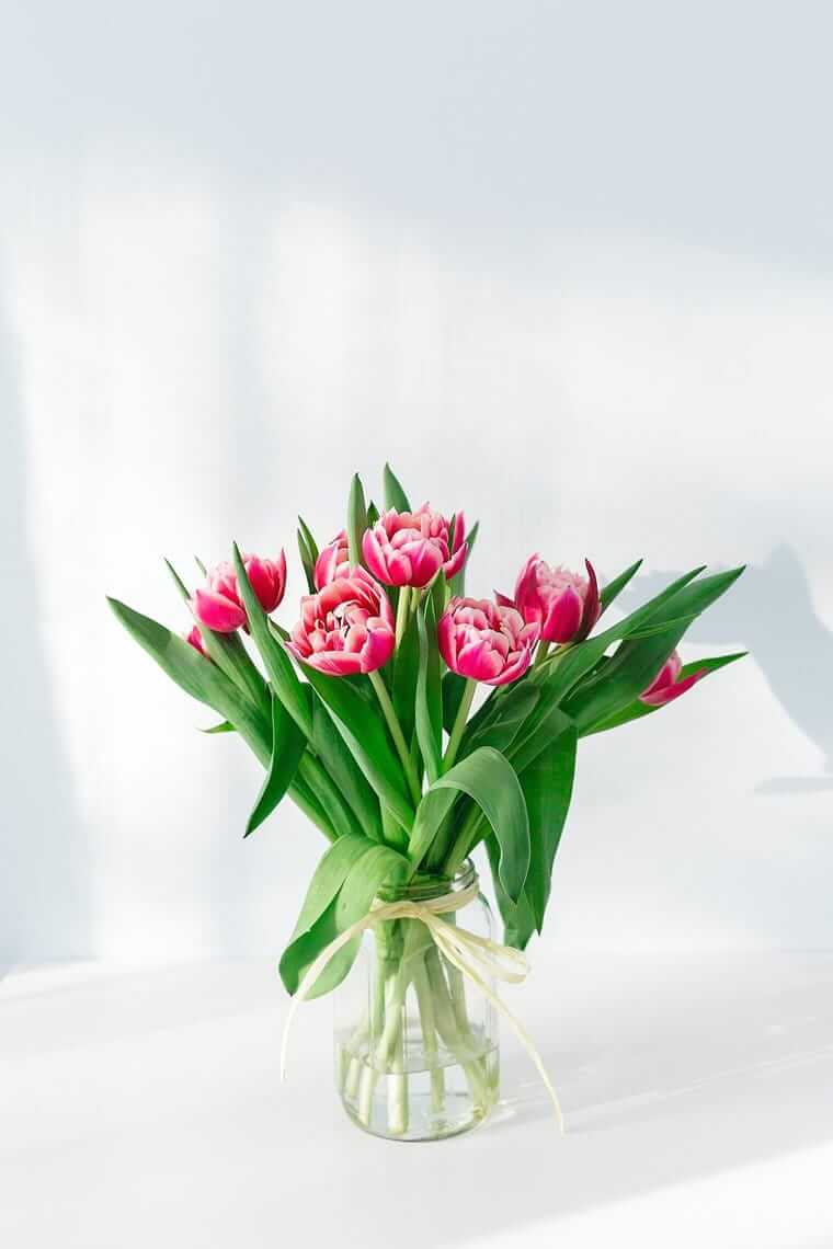 Blumen (Herzstück aus rosafarbenen Blütenblättern in einer Vase aus klarem Glas)