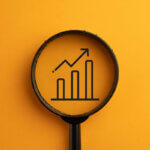 Finanzierung / Growthing Bar concept.,View through a magnifying glass on growthing Chart icon over orange background.