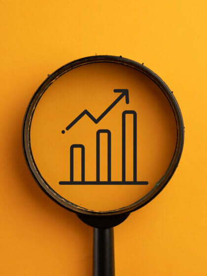Finanzierung / Growthing Bar concept.,View through a magnifying glass on growthing Chart icon over orange background.