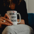 Führungsqualität Frauen / Frau mit Tasse „World’s Best Boss“ in der Hand, Lippenstiftabdruck sichtbar – Symbolbild für weibliche Führung und moderne Leadership-Qualitäten