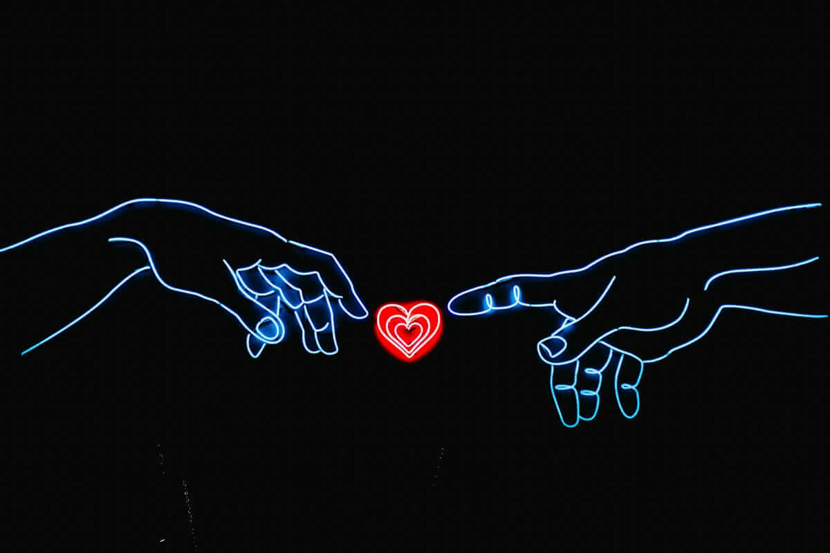 Mitarbeitergewinnung (Zwei stilisierte Hände in Neonoptik greifen nach einem roten Herz – Symbol für Verbindung zwischen Mensch und digitalem Recruiting)