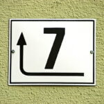 erfolgreicher Unternehmer, Eigenschaften (Schild mit der Zahl 7 und einem Richtungspfeil – Symbol für unternehmerische Entscheidungen und Veränderung.)