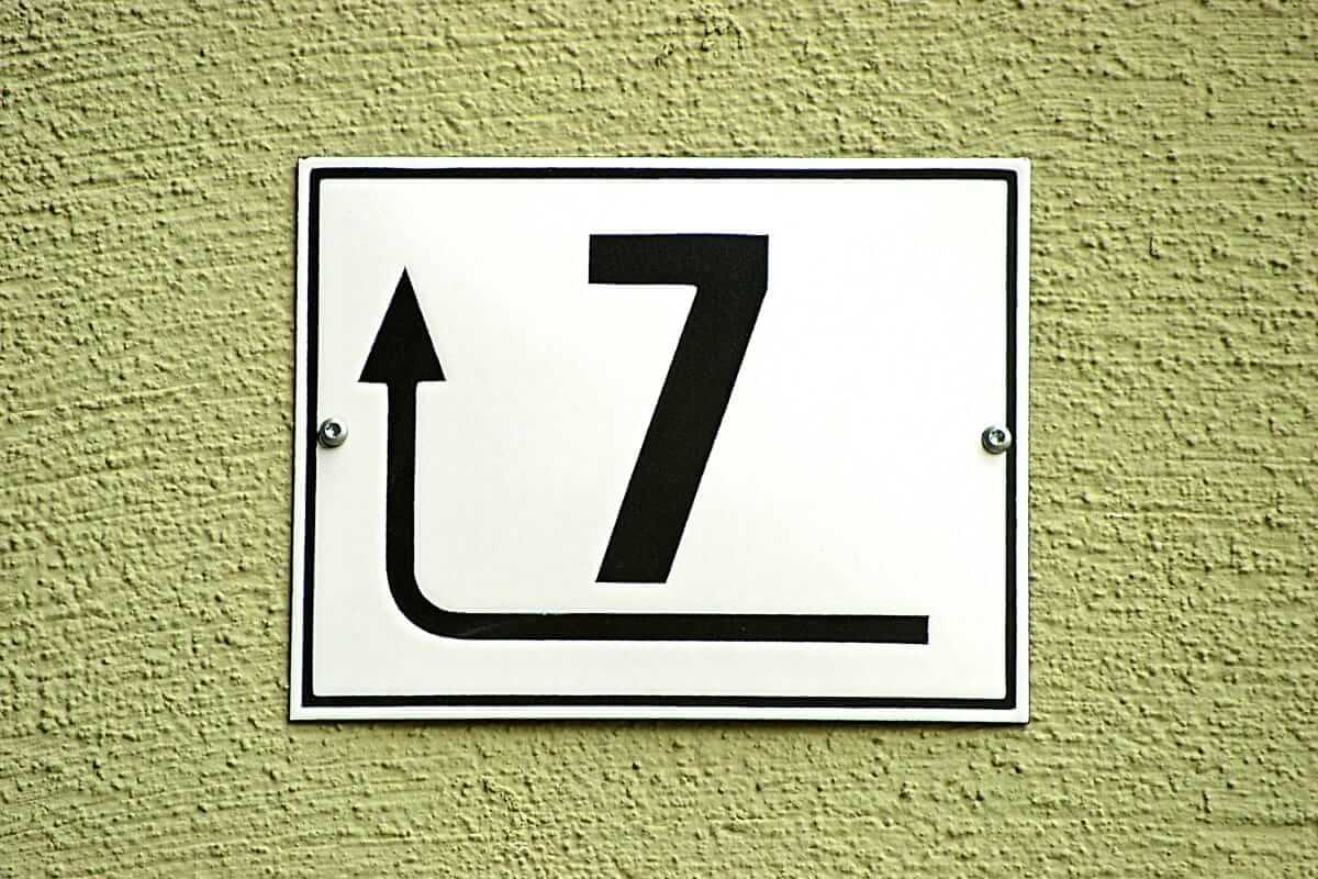 erfolgreicher Unternehmer, Eigenschaften (Schild mit der Zahl 7 und einem Richtungspfeil – Symbol für unternehmerische Entscheidungen und Veränderung.)