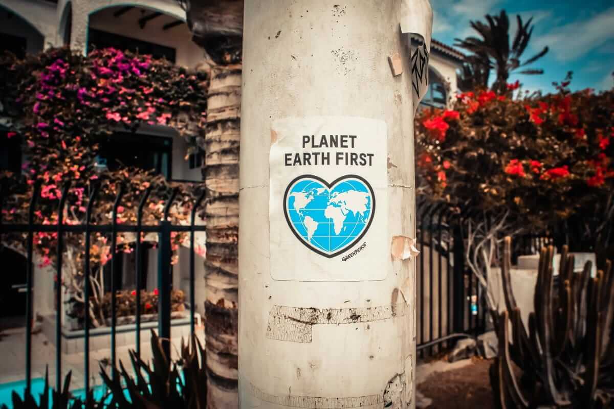 Sticker mit der Aufschrift 'Planet Earth First' auf einem Pfeiler – symbolisiert Umweltbewusstsein, Engagement für Nachhaltigkeit und globale Verantwortung.