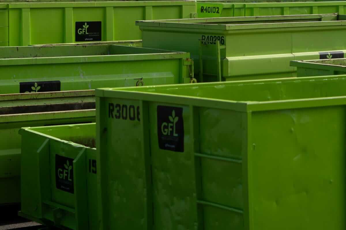 Gestapelte grüne Mehrwegbehälter in einem Industriehof – Symbol für effizientes Ladungsträgermanagement und nachhaltige Logistikprozesse.