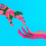 künstliche Intelligenz / Roboterhand und menschliche Hand berühren sich vor türkisfarbenem Hintergrund als Symbol für die Zusammenarbeit von Mensch und künstlicher Intelligenz.