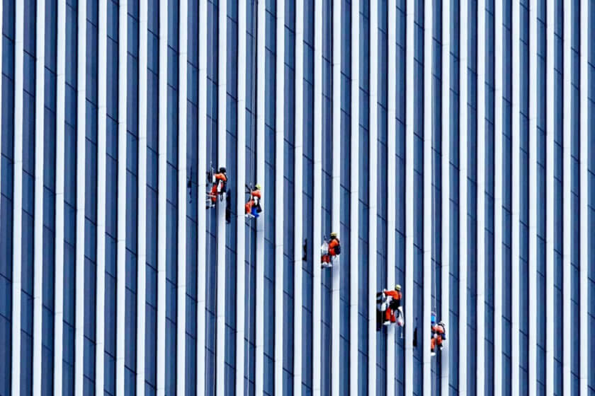 Nebenerwerb / Menschen arbeiten an einer Hochhausfassade – Symbol für Stabilität, Eigeninitiative und den Weg in die Selbstständigkeit