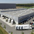 E-Commerce as a Service / Luftaufnahme des IDEAL-GROUP Logistikstandorts mit mehreren Lagerhallen, Laderampen, Lkw im Be- und Entladebereich sowie angrenzenden Parkflächen.