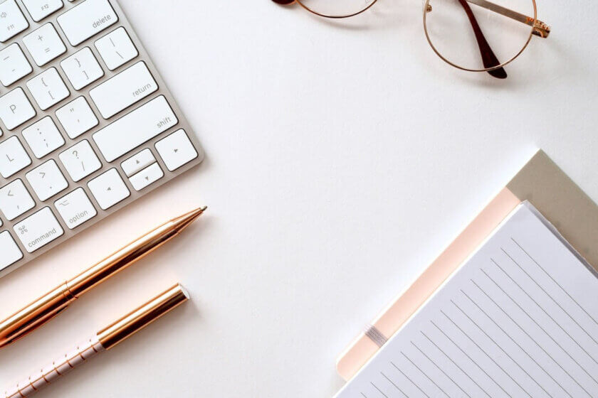 Sichtbarkeit / Minimalistischer Arbeitsplatz mit Tastatur, Notizbuch und Stift – Symbol für unternehmerische Planung und fokussierte Entscheidungen