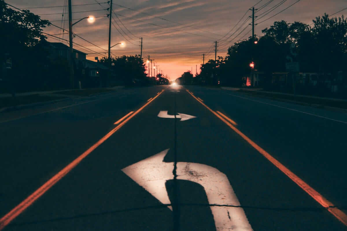 Teambuilding: sinnvolle Investition oder teurer Aktionismus? Straßenmarkierung mit zwei Richtungen als Symbol für die Entscheidung zwischen sinnvoller Investition und teurem Aktionismus im Teambuilding