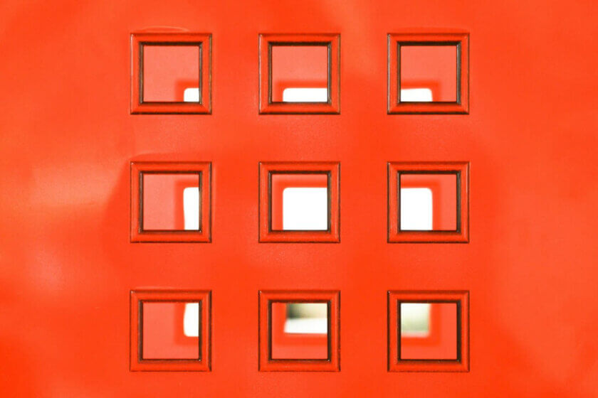 Digitale Ordnung / Symmetrisch angeordnete quadratische Fenster in roter Fläche als Symbol für Ordnung, Struktur und systematische Abläufe.