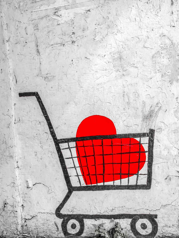 Shopsystem wählen: Welches passt zu deinem Business? (Vergleich + Checkliste) Einkaufswagen-Graffiti mit rotem Herz auf Betonwand – Symbolbild für E-Commerce und Online-Shopping