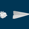 Zerknülltes Papier neben einem gefalteten Papierflieger – Symbol für den Wandel von der Idee zur Innovation