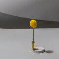 Prioritäten setzen (Gelbe Kugel auf schlankem Stiel vor neutralem Hintergrund als Symbol für Fokus und klare Prioritäten im Führungsalltag)
