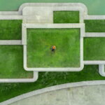 was du in den ersten 30 Tagen erledigen musst / Person steht allein in der Mitte eines geometrischen Wegesystems, Luftaufnahme.