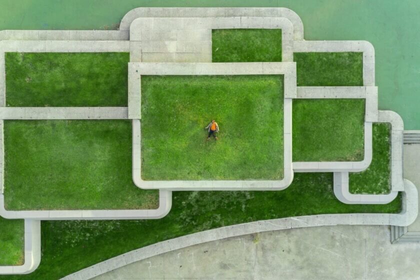 was du in den ersten 30 Tagen erledigen musst / Person steht allein in der Mitte eines geometrischen Wegesystems, Luftaufnahme.