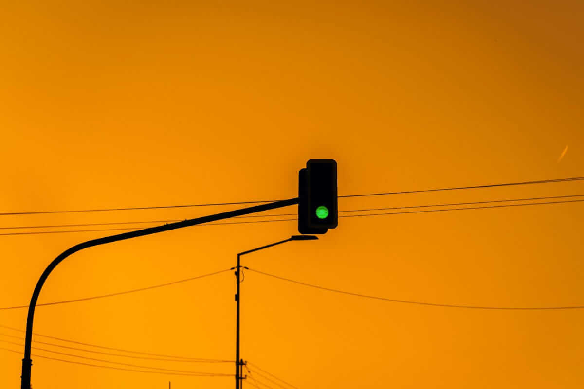 Grüne Ampel vor orangefarbenem Abendhimmel – klares Signal für strukturierte Meetings mit Regeln und Fokus.