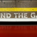 "Mind the Gap"-Schriftzug an einer Londoner U-Bahn-Wand mit rotem Waggon im Vordergrund — Symbol für die Rentenlücke bei Selbstständigen