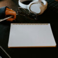 Praktikanten und Mindestlohn / Leerer Schreibtisch mit aufgeschlagenem Notizbuch und Stift — Praktikum vorbereiten als Arbeitgeber