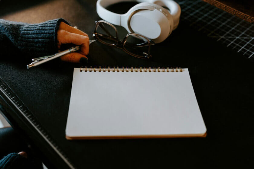 Praktikanten und Mindestlohn / Leerer Schreibtisch mit aufgeschlagenem Notizbuch und Stift — Praktikum vorbereiten als Arbeitgeber