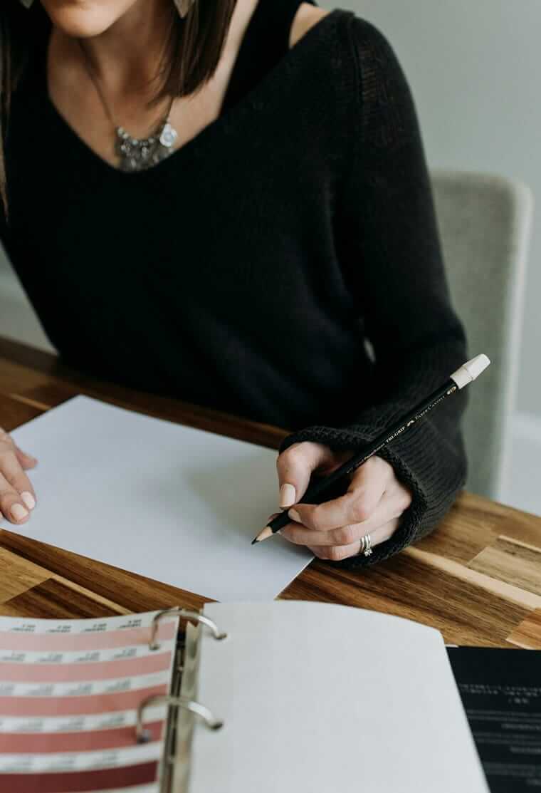 Praktikanten und Mindestlohn / Person hält Bleistift über Unterlagen am Schreibtisch — Praktikumsvertrag und Rechte für Arbeitgeber