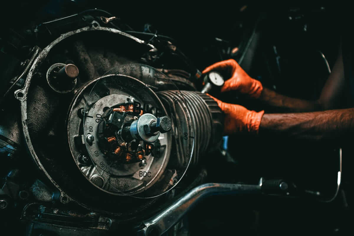 Mechaniker mit roten Schutzhandschuhen bei der Arbeit an einem Motorrad – Wartung und technischer Wandel als Argument für Leasing.