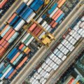 B2B-Einkauf / Luftaufnahme eines Containerterminals mit farbigen Frachtcontainern und Verladekran