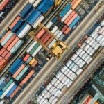 B2B-Einkauf / Luftaufnahme eines Containerterminals mit farbigen Frachtcontainern und Verladekran