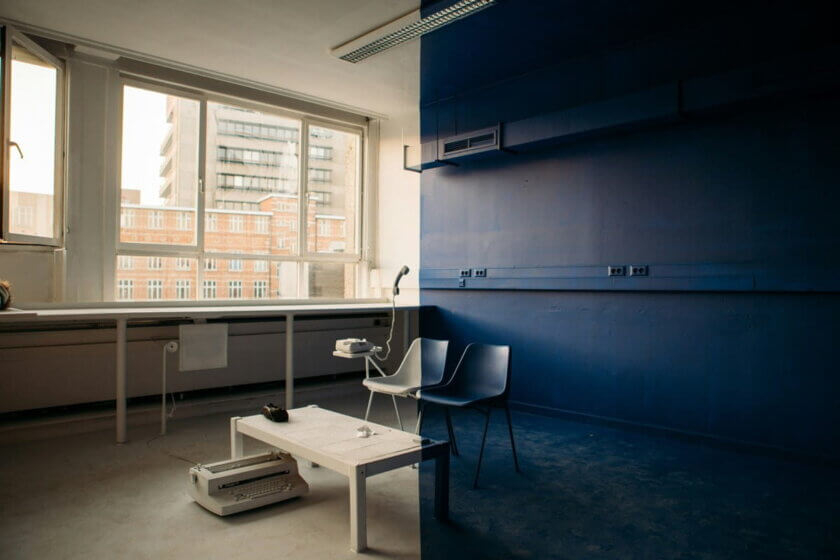 Leerer Büroraum mit zwei Stühlen und einer alten Schreibmaschine auf dem Boden — Symbol für den Wandel in der Arbeitswelt und den wachsenden Fachkräftemangel.