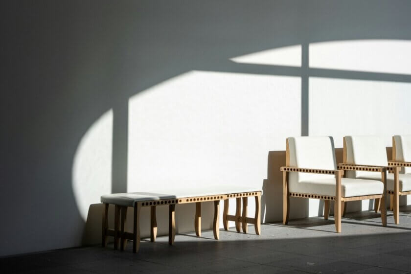 Neukundengewinnung / Leerer Wartebereich mit hellen Sesseln im scharfen Schattenwurf eines Fensters – Sinnbild für Struktur statt Zufall in der Kundengewinnung