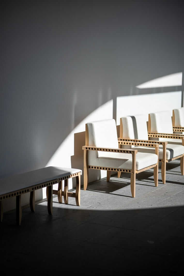 Neukundengewinnung / Reihe heller Lounge-Sessel im Streiflicht – Sinnbild für durchdachte Struktur statt zufälligem Vorgehen