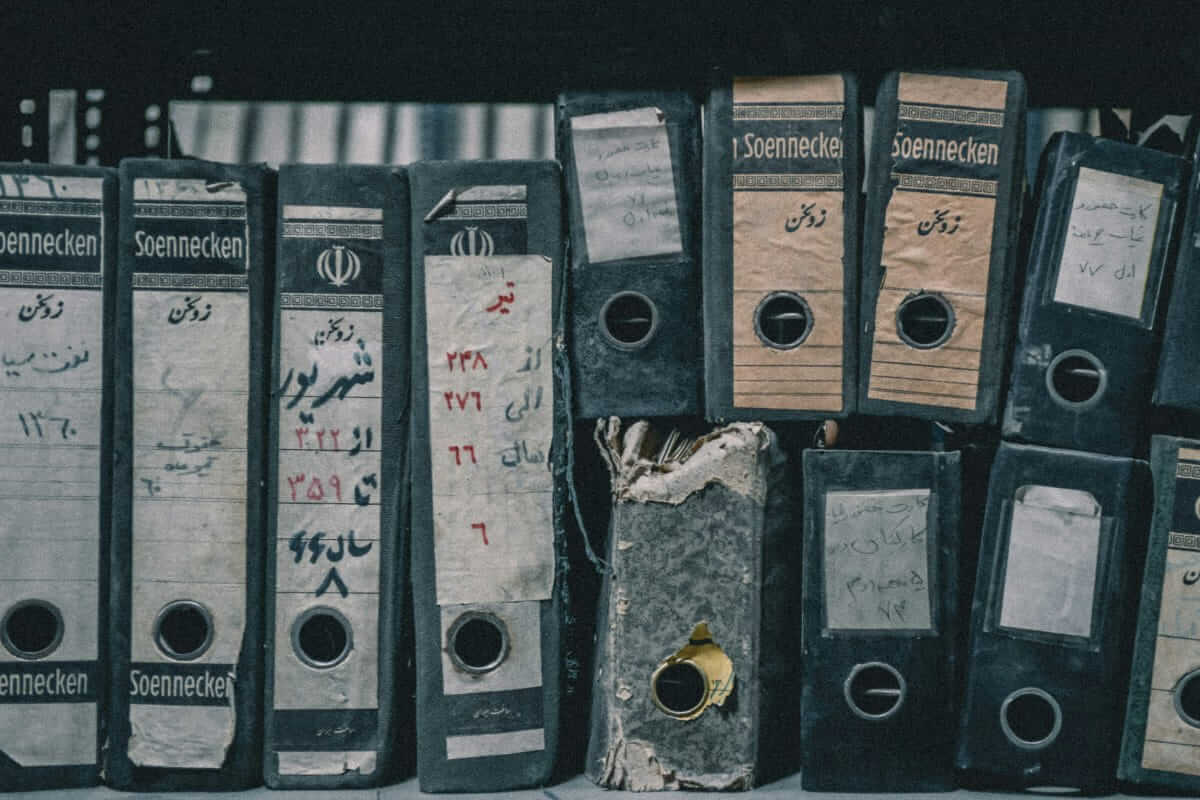 GoBD-konforme Prozesse: Wie Unternehmen Belege und Dokumente digital organisieren GoBD / Reihe alter, verwitterter Aktenordner mit handgeschriebenen Beschriftungen – Symbol für analoge Dokumentenverwaltung vor der Digitalisierung.