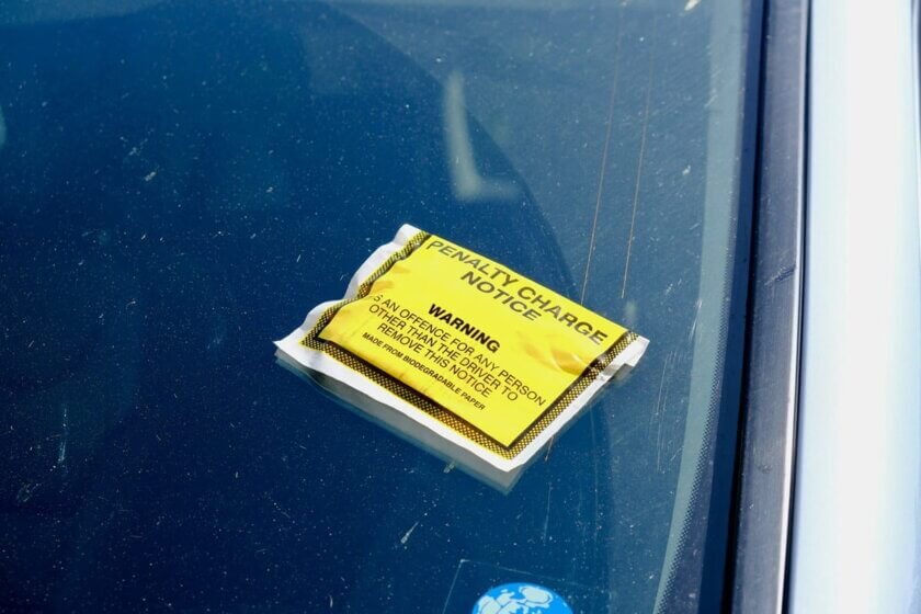 Verspätungszuschlag, Zwangsgeld / Gelber Penalty Charge Notice Strafzettel auf der Windschutzscheibe eines Autos