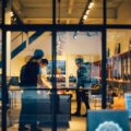 Neue Verkaufsflächen / Blick durch eine Glasfassade in einen modern eingerichteten Laden mit Kunden – Einblick in eine gestaltete Verkaufsfläche im Einzelhandel.