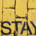 Probezeit / Gelbe Pflastersteine mit dem aufgesprühten Schriftzug STAY