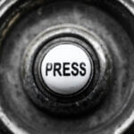 Verwitterter PRESS-Knopf in Nahaufnahme – Symbolbild für den Handlungsdruck bei Betriebsmittelfinanzierung