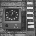 Stechuhr mit Stempelkarten an einer Backsteinwand – Symbol für Arbeitszeiterfassung und Beschäftigung auf Abruf