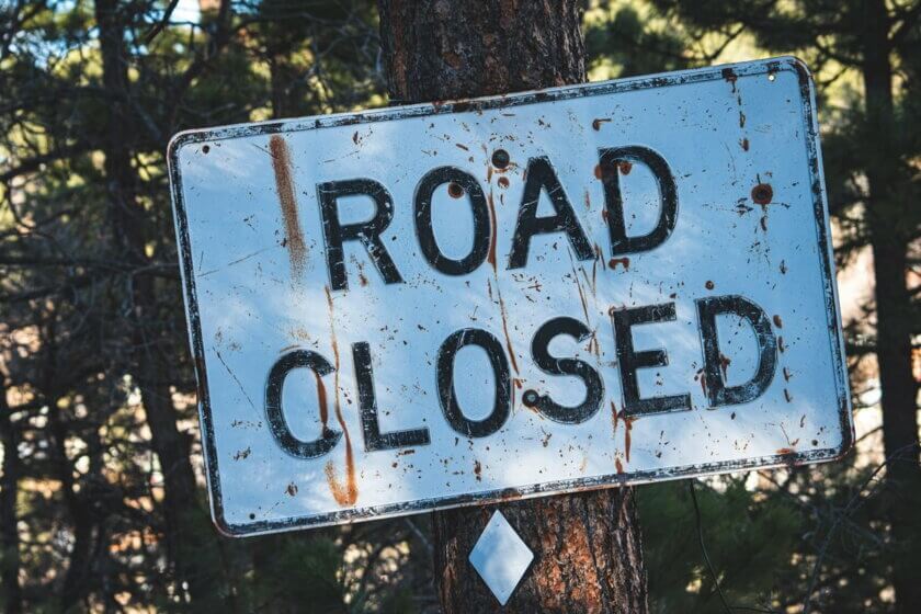 Rentenversicherungspflicht / Verwittertes Road-Closed-Schild an einem Baum – Symbol für auslaufende Regelungen zur Altersvorsorge Selbständiger